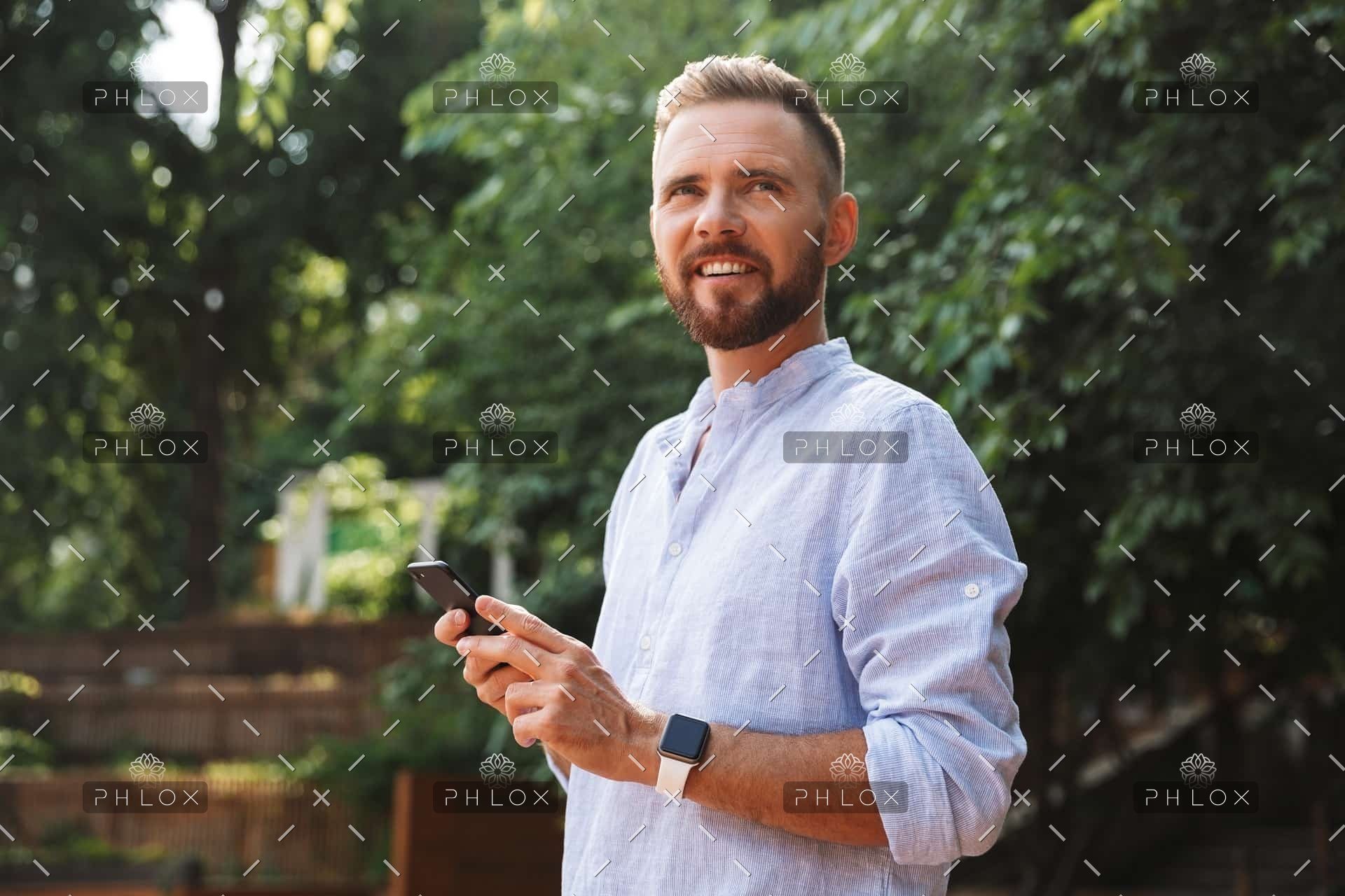 demo-attachment-437-op_happy-young-bearded-man-outdoors-using-mobile-B9D43PN